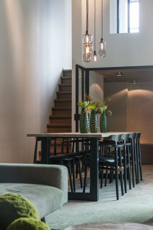 a glass chandelier hanging from a ceiling above a table with chairs