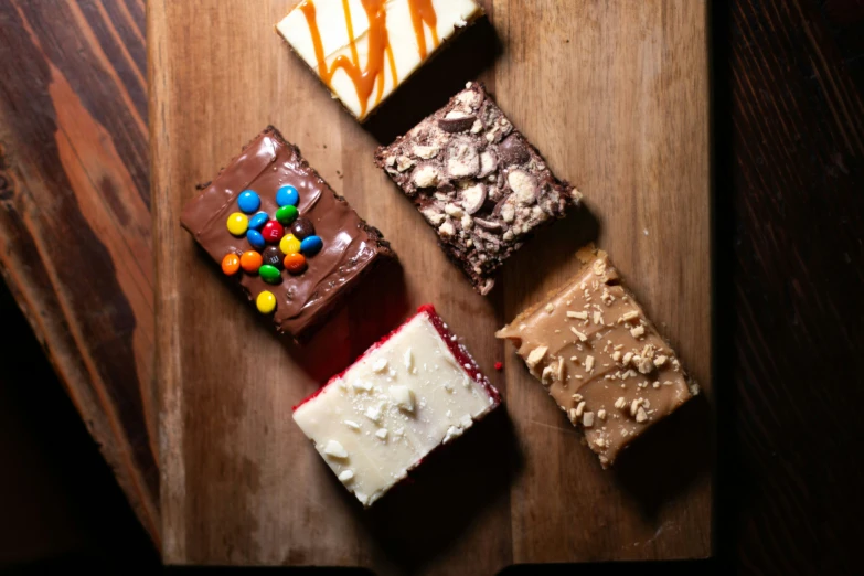 a variety of desserts sitting on a wooden board