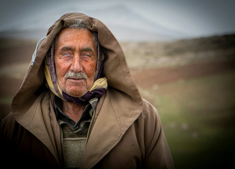 a man with a hood on stands by himself