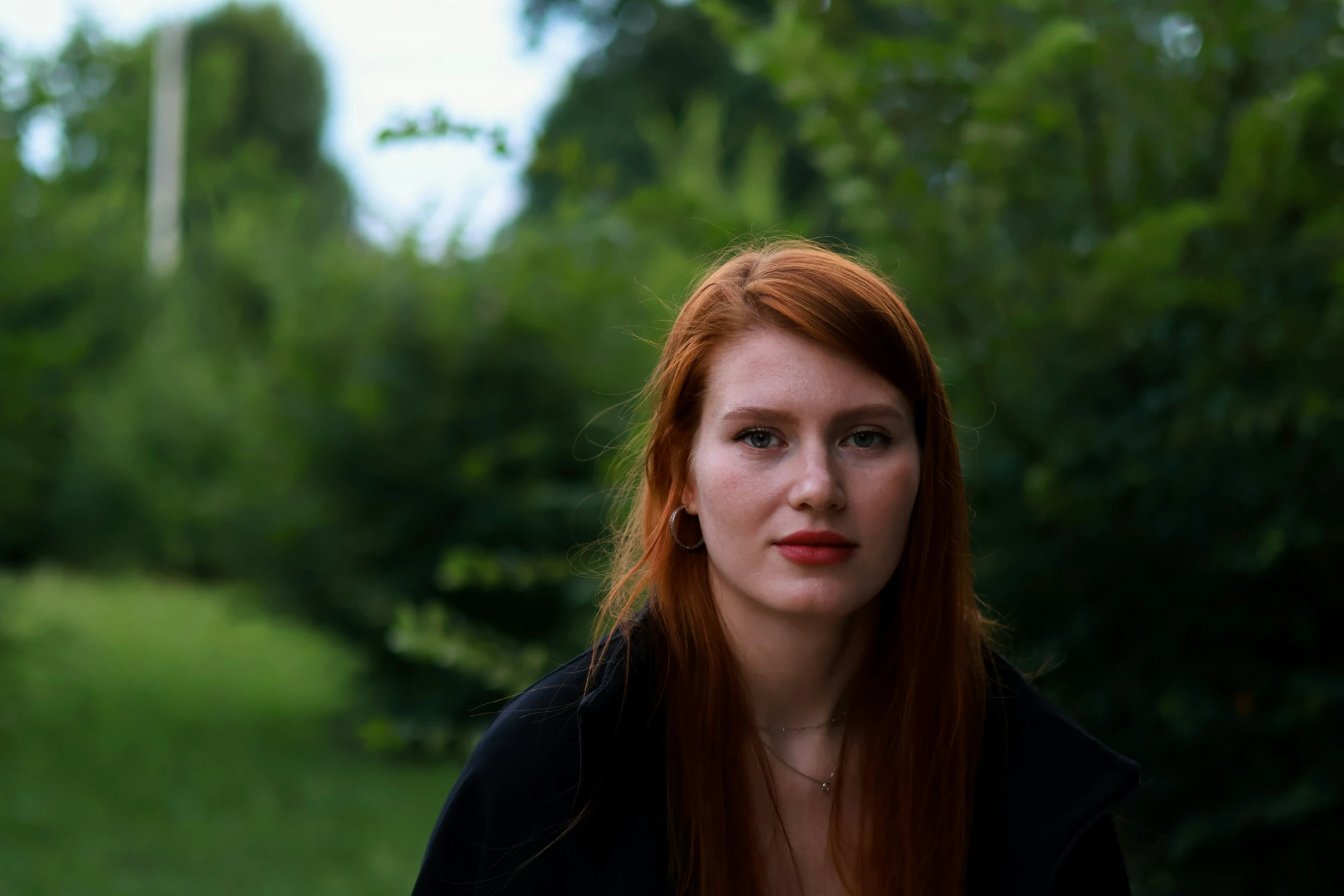 a woman with red hair looks into the camera