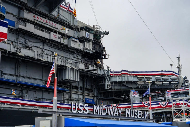 an aircraft carrier with a banner reading uss midway music