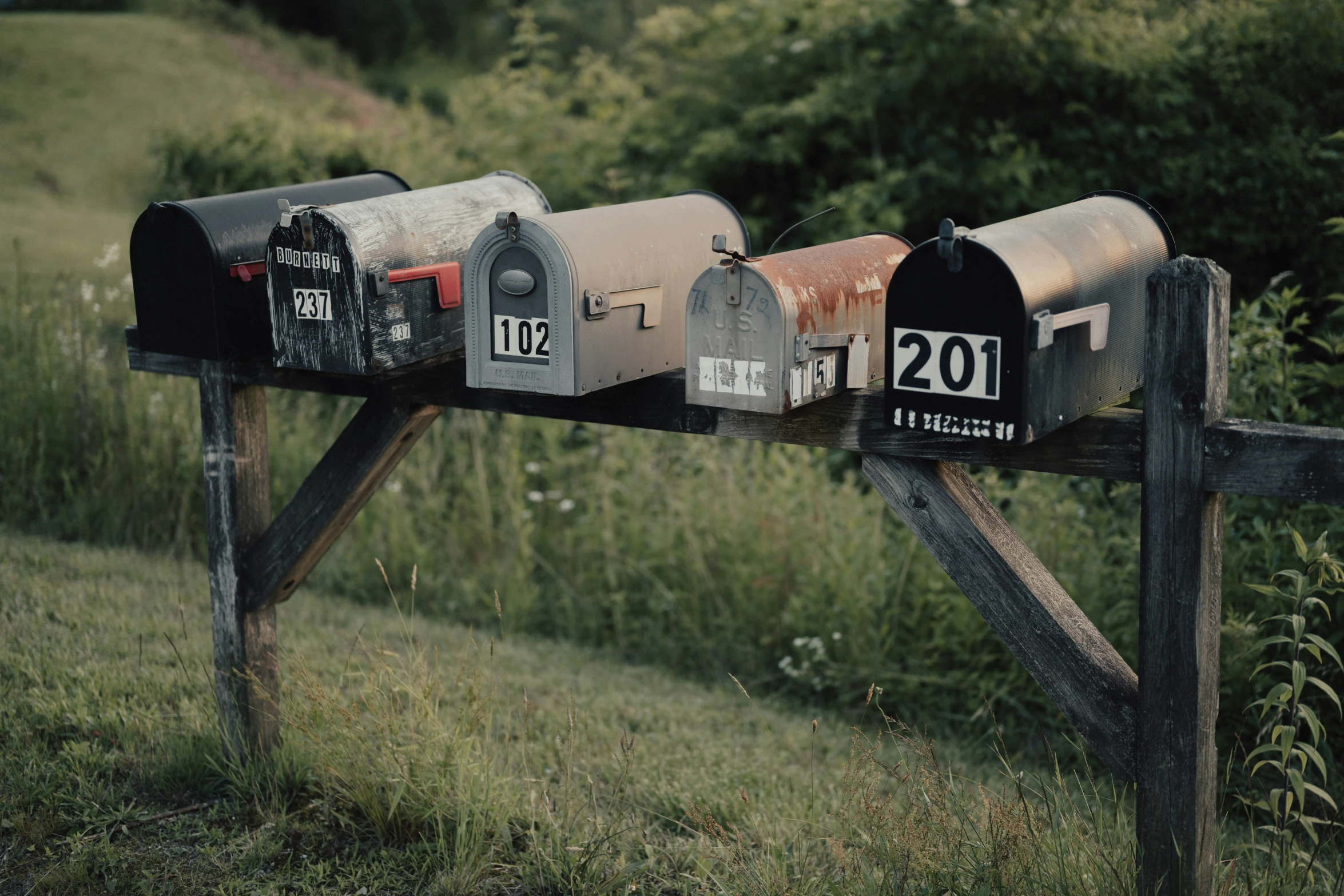 a number of mail boxes that are in front of a fence