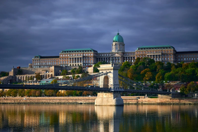 a bridge over a body of water in front of a building with towers