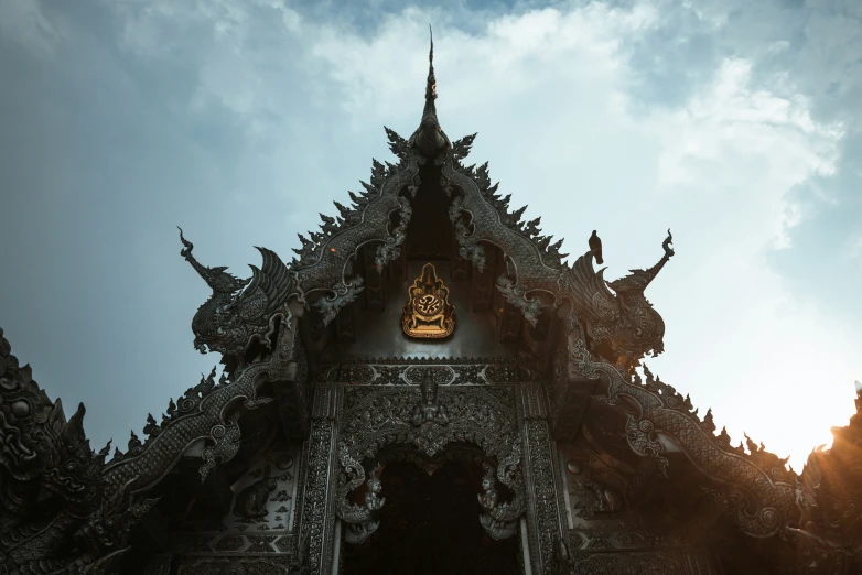 an ornate building with statues and clocks at the top