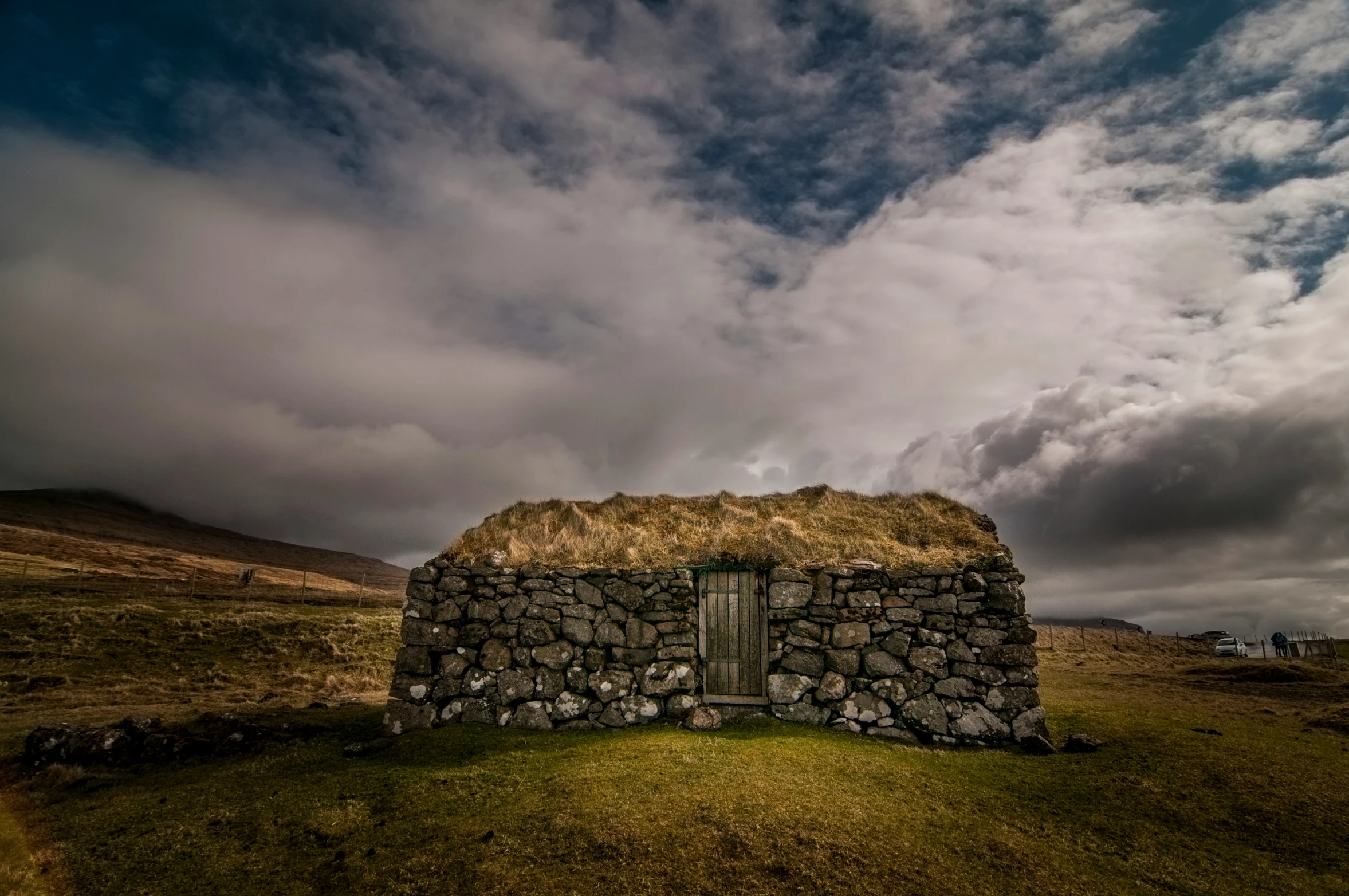 an old stone building sitting in the middle of a field