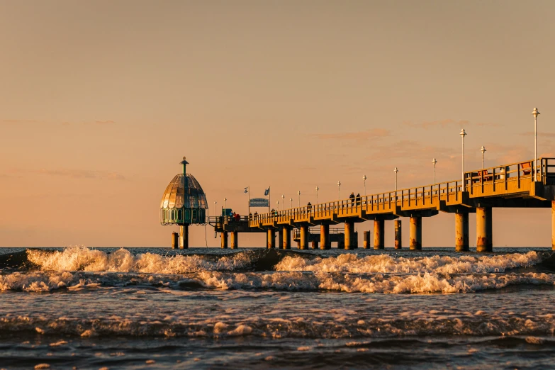 pier and surfboard at sunset on a cloudy day