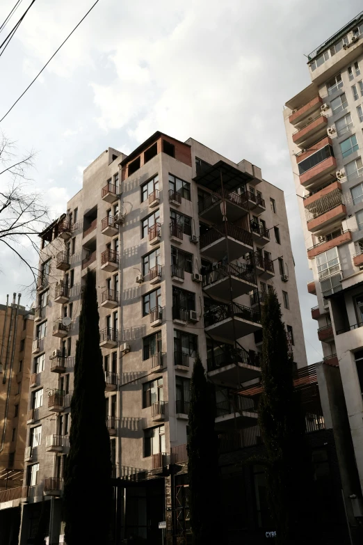 an apartment building sits between two other buildings