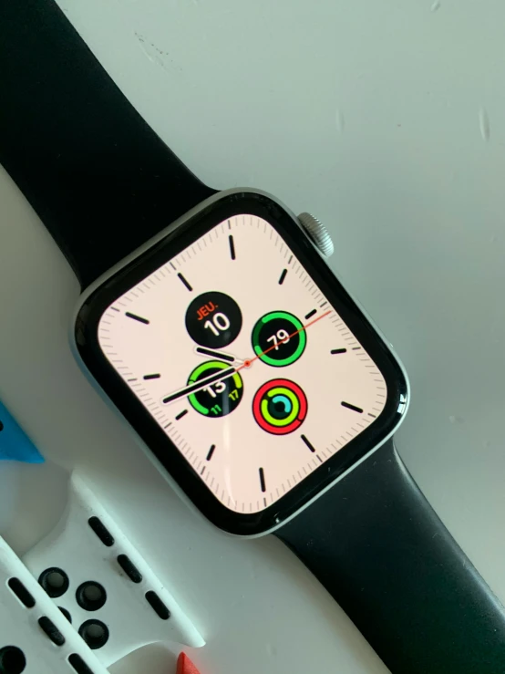 an apple watch sitting on top of a table next to some markers