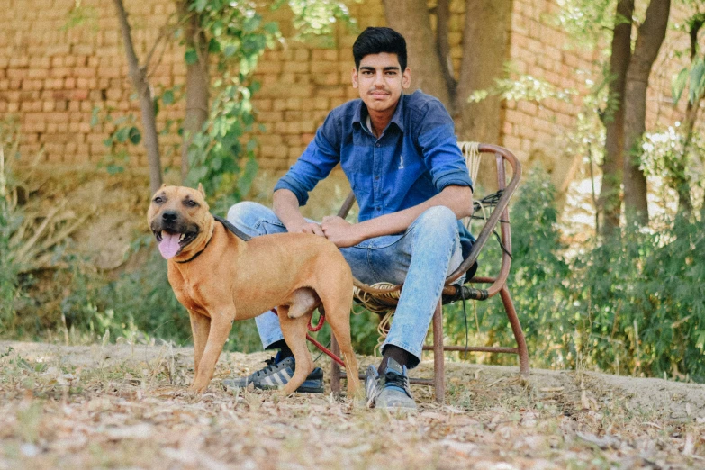 a man sitting on a wooden chair with a dog