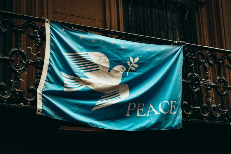 a large blue flag sitting above a fence