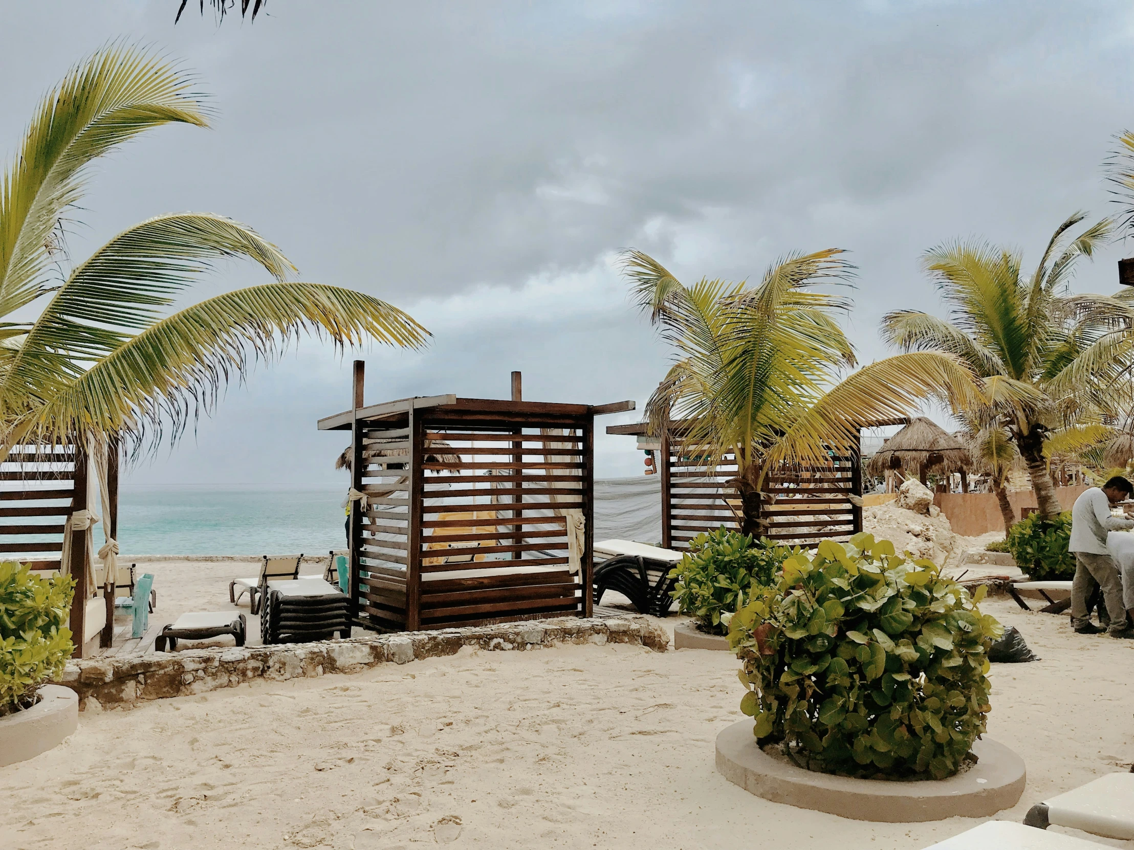 an outdoor beach bar on the sand near a body of water