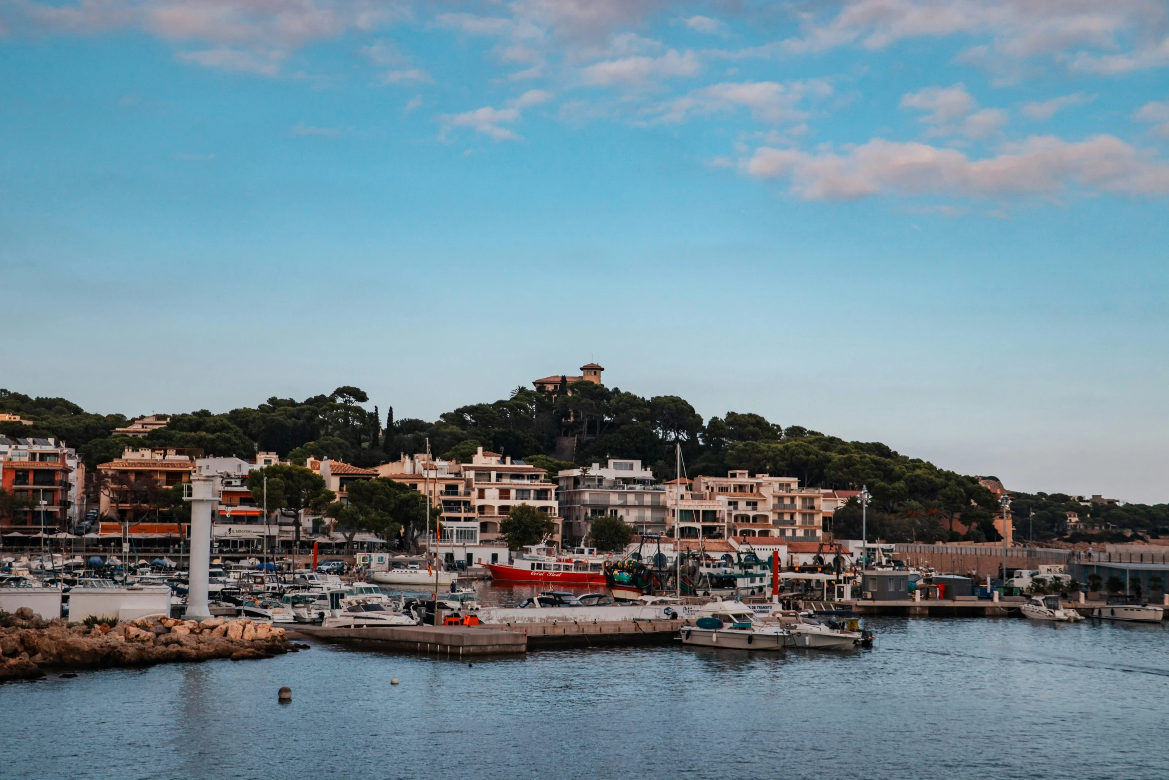 a harbor filled with lots of boats under a blue cloudy sky