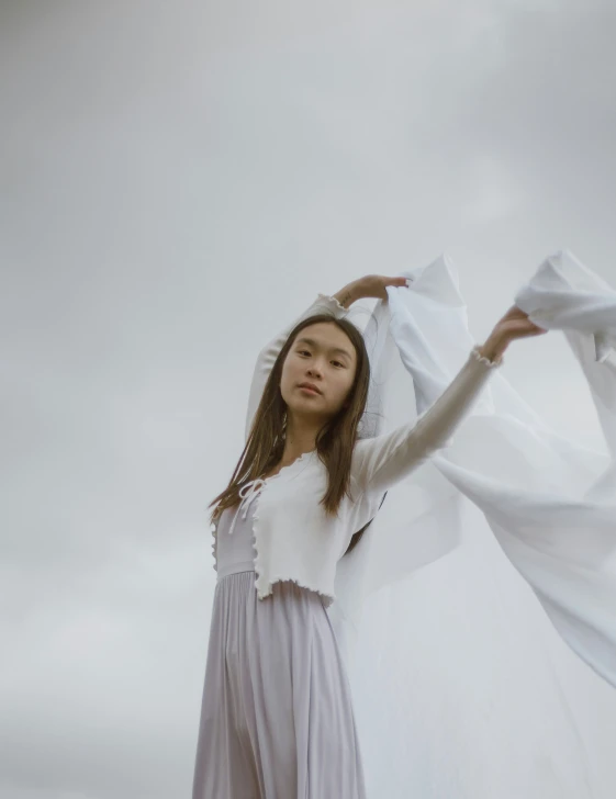 a woman in white holding onto white fabric