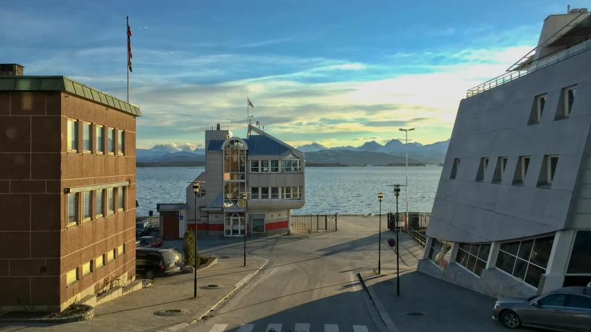 two buildings with mountains in the background and water