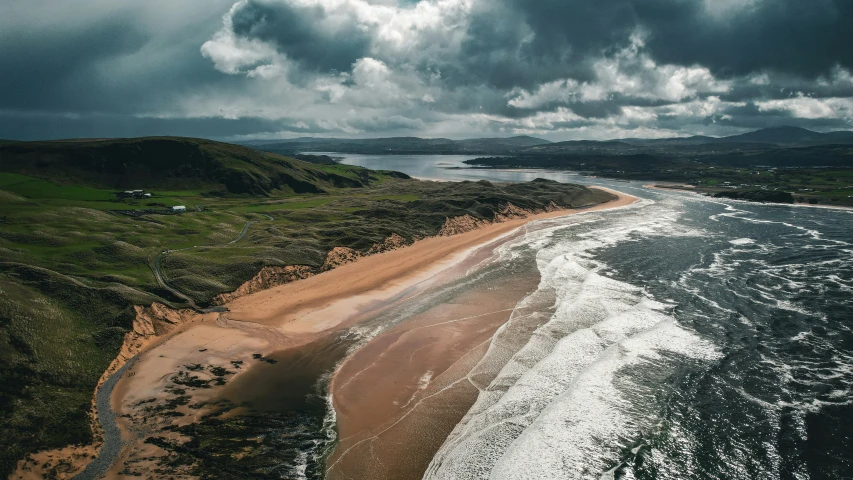 the beach and water are under stormy skies