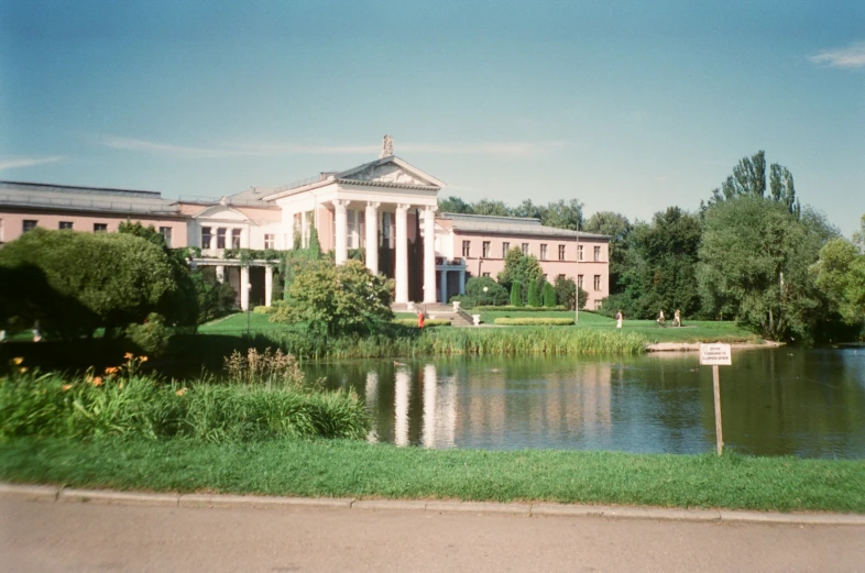 a beautiful building on the side of a pond