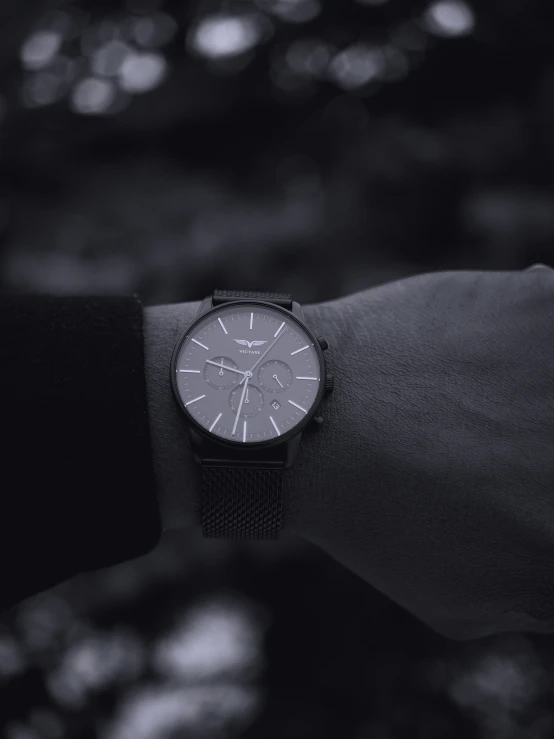 a black and white image of a wrist with a watch on it
