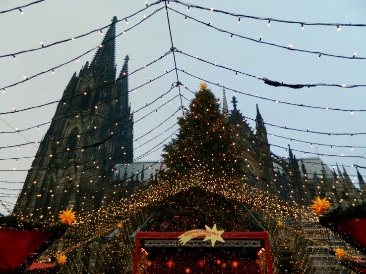 an elaborate cathedral adorned with christmas lights under a blue sky