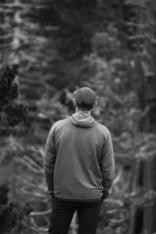 a man looks at some trees, black and white image