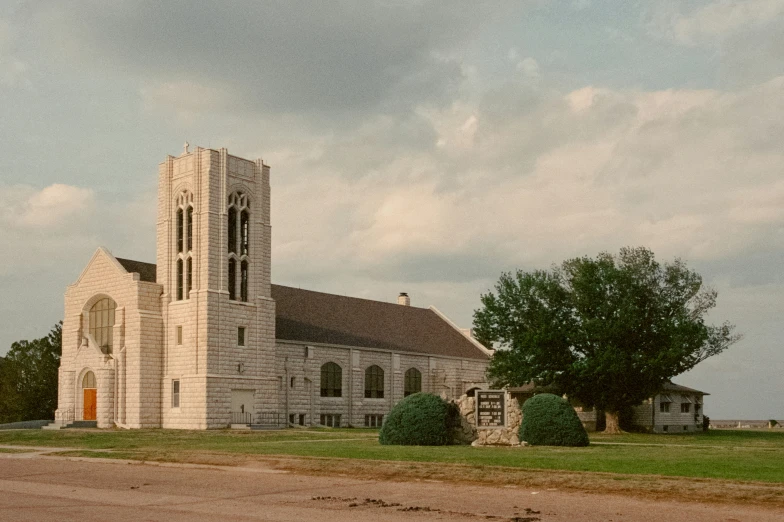 an old church in an open field with trees