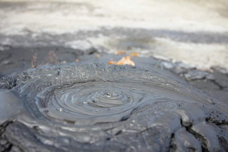 a large circular object surrounded by water and rocks