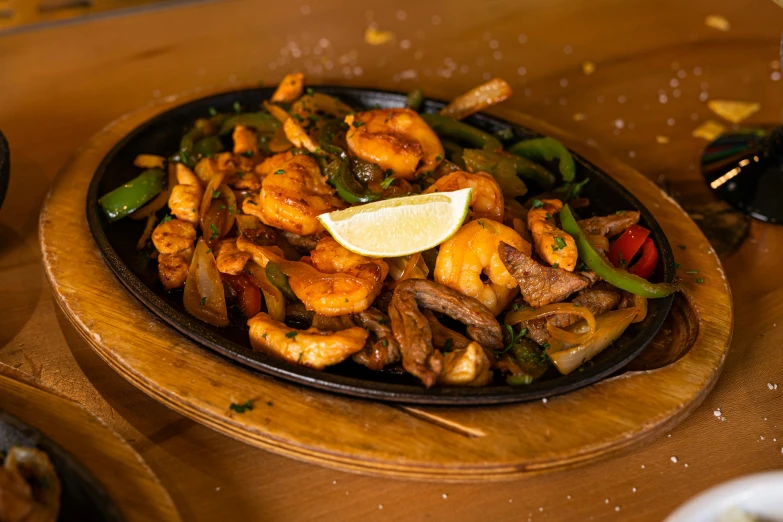 shrimp and vegetable dish displayed in black ceramic bowl