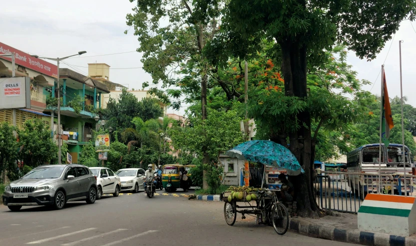 this street is quiet, with cars and people with umbrellas on the street