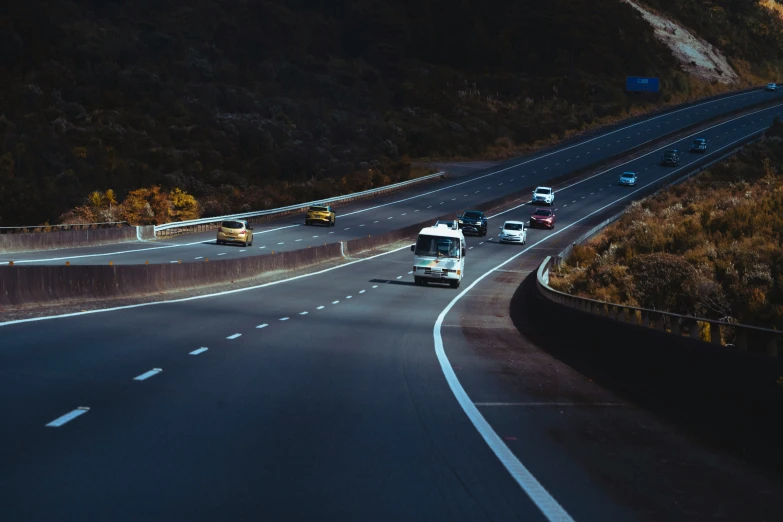 a couple of cars are driving down a curved road