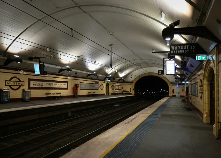 an empty subway station with people walking on the platform