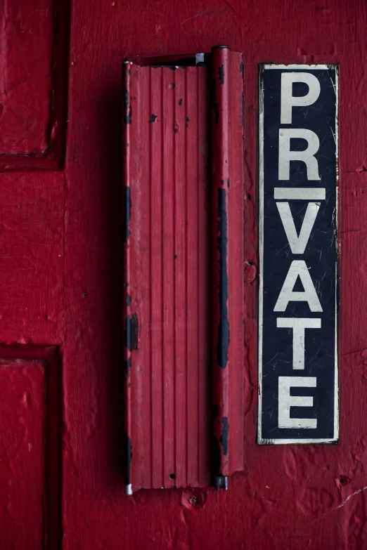 the door of a private property on red painted wall