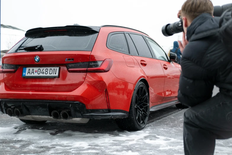 red car is parked in a snowy parking lot