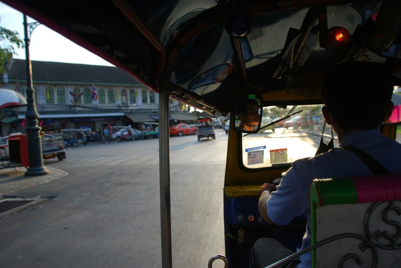 view of the inside of a rickshaw bus going down the road