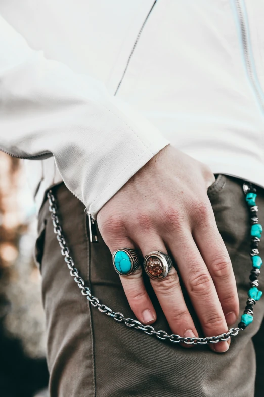 a person wearing a turquoise ring and beaded celet