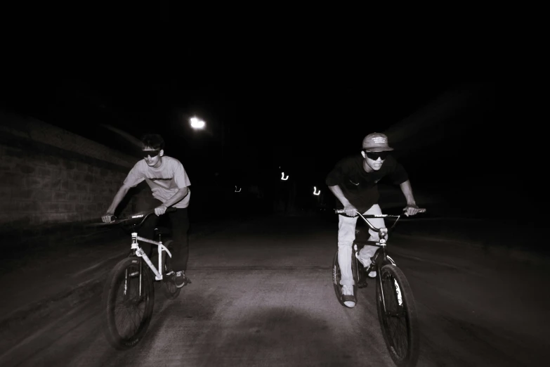 two men riding their bikes on the road