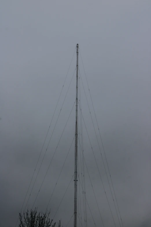 a antenna on the top of a building with grey clouds