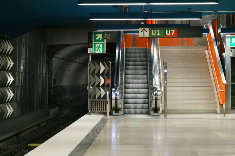 an empty subway station with two stairs leading to the exit