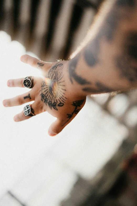 a tattooed man's hand is shown from above