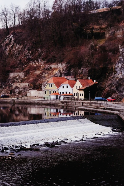 houses at the base of a hill near water