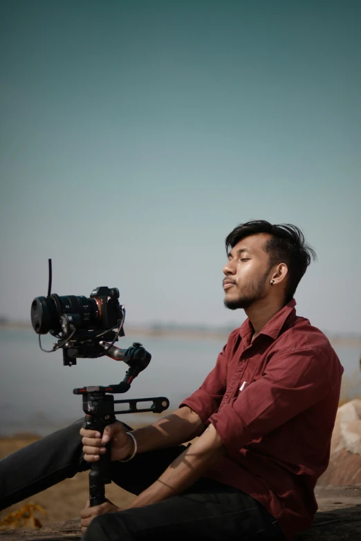 a man on a wooden bench with a camera