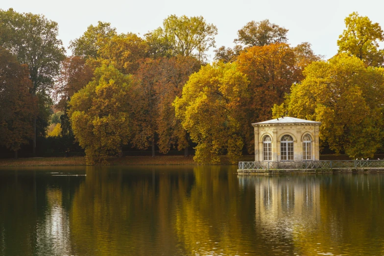 a small white gazebo near a large lake