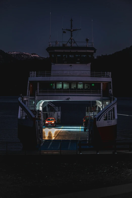 a white and red boat at night on the water