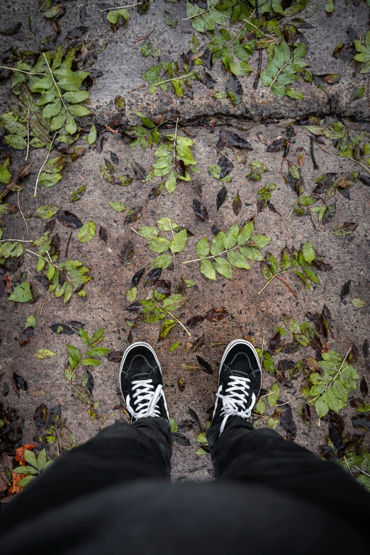 a persons feet with black and white sneakers