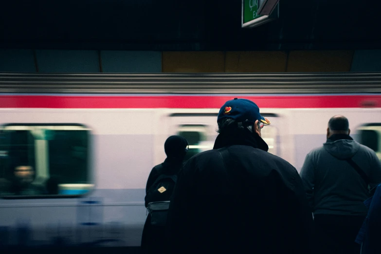 a crowd of people standing next to a subway