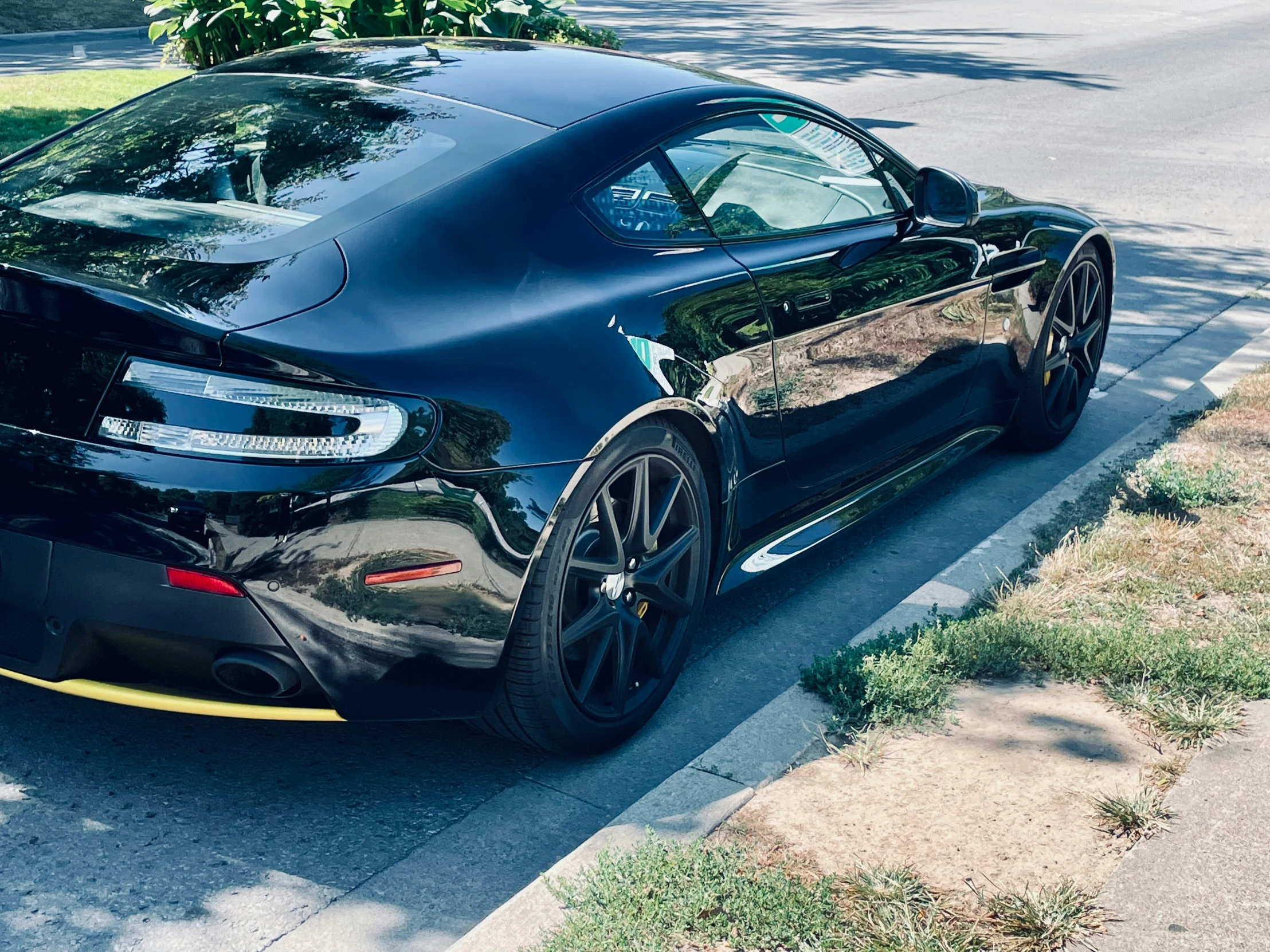 the black sports car is parked by the curb