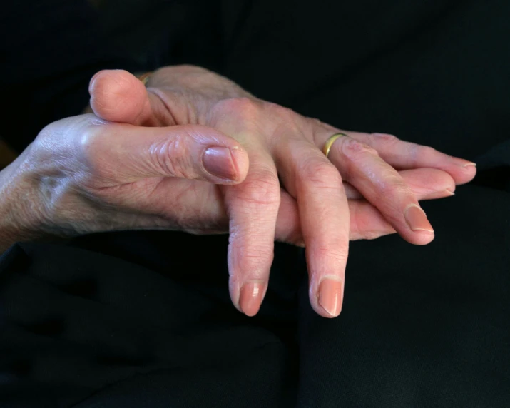 an old person holding a younger woman's hand with both fingers