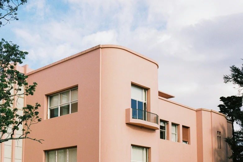 a tall pink building with white windows