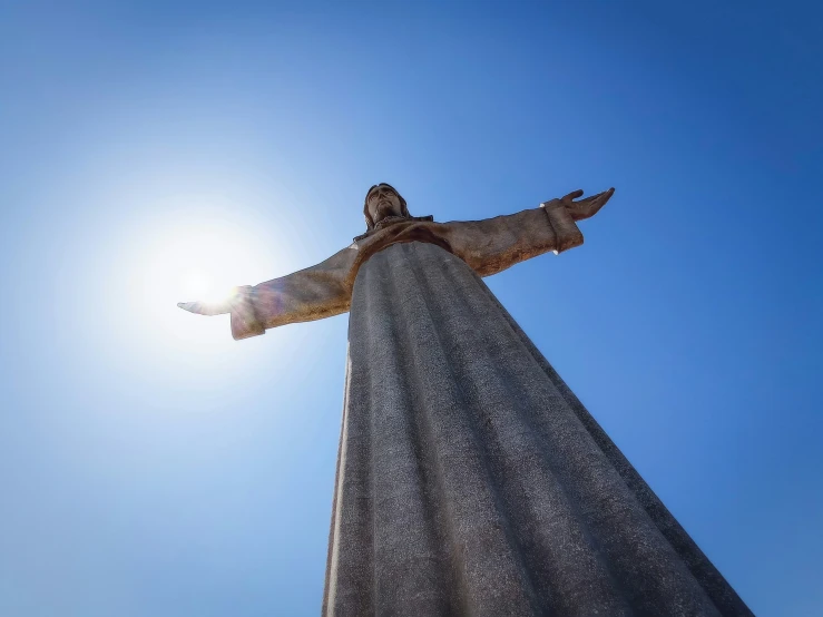 a large statue of jesus in front of the sun