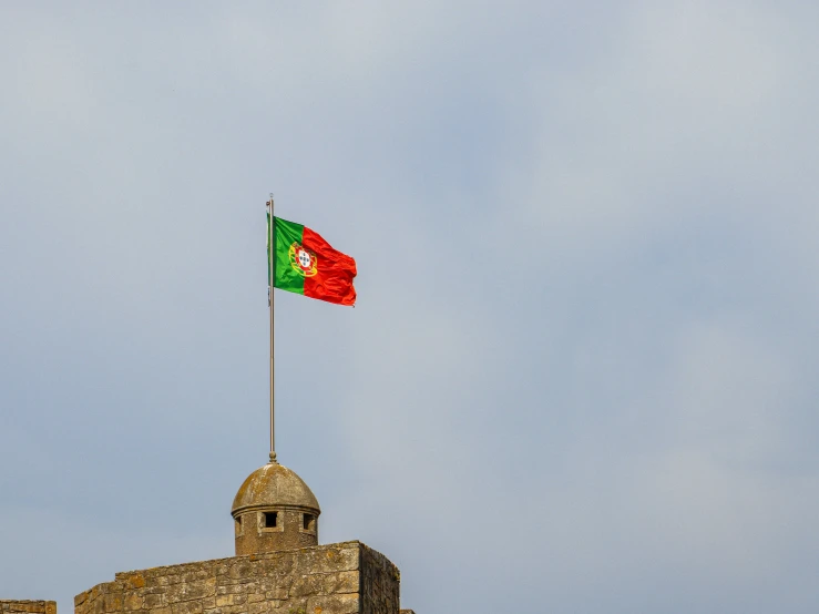 an flag flying high over a stone building