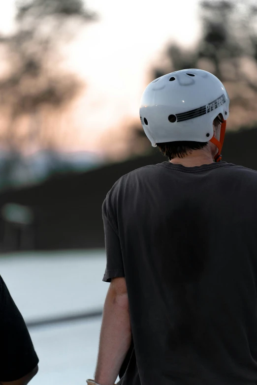 two people standing next to each other wearing helmets