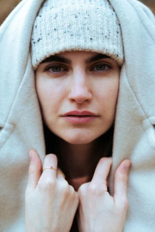 a woman holding her hat over her head